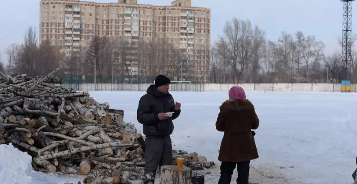 Locals have hot food and tea distributed by the Ukrainian military in Avdiivka.