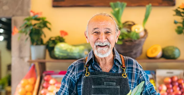 Elderly worker sells fruits. 