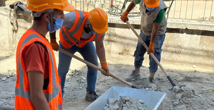 Community workers rehabilitating sidewalks surrounding a public park in Kadi Askar for a safer communal space