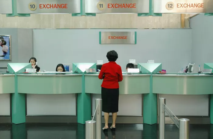 Woman exchanging money at counter.