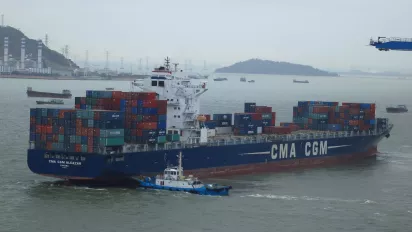 A tug pushes a cargo ship exiting the Port of Chiwan, in Guangdong province, China.