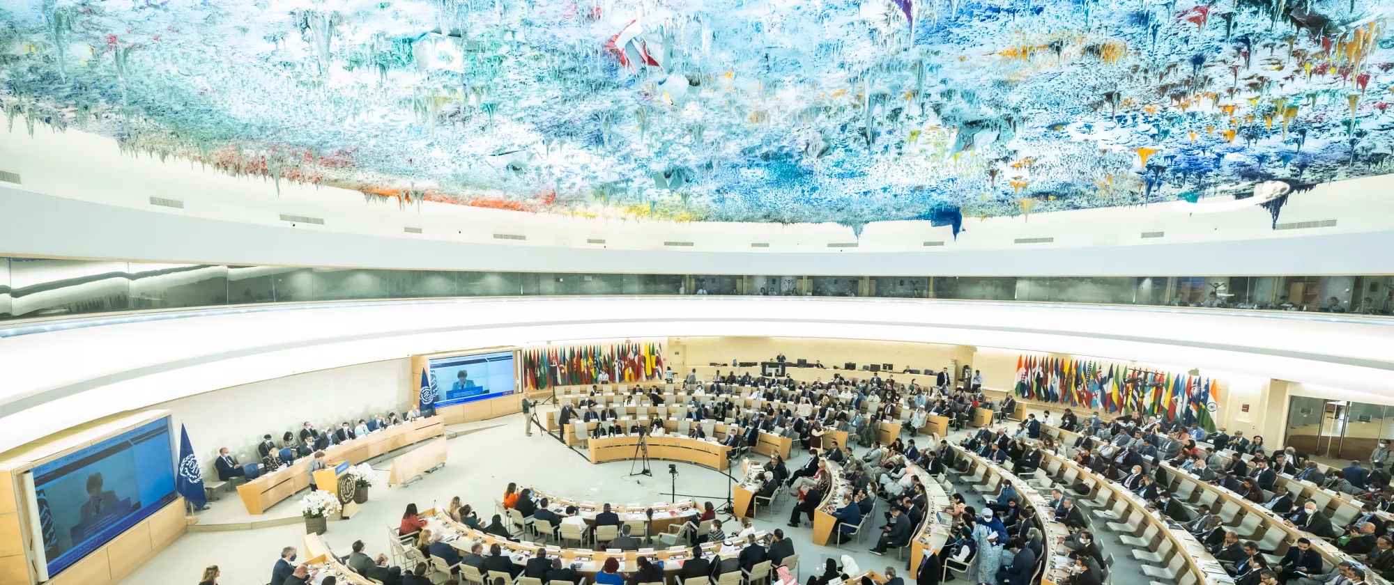 People gathering at a large meeting room.