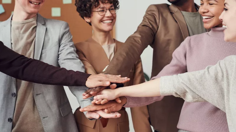 Six people of different races shaking hands